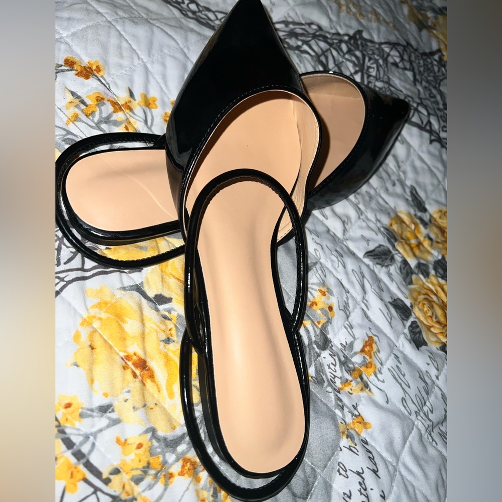 Black pointed-toe flats. Offers welcome